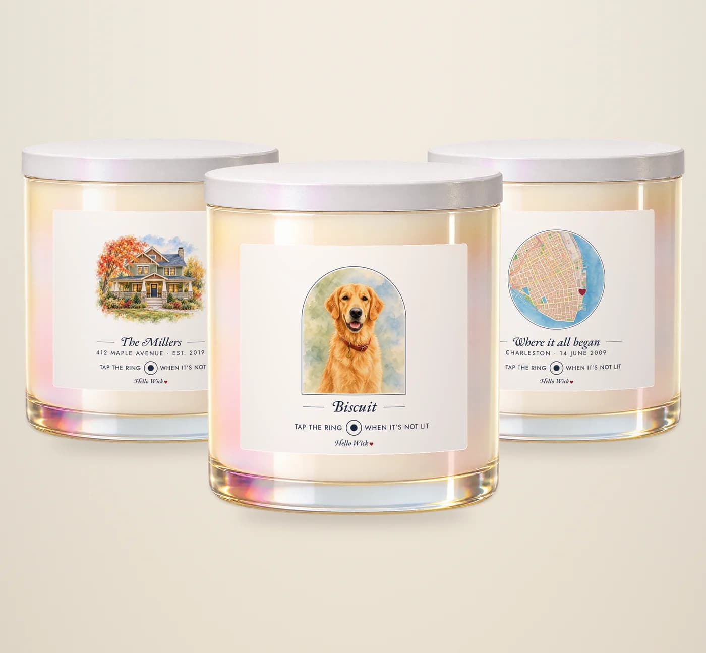 Three Hello Wick candles: Biscuit with a watercolour of the dog in an arch, The Millers with a watercolour of their house, and Where it all began with a round watercolour map