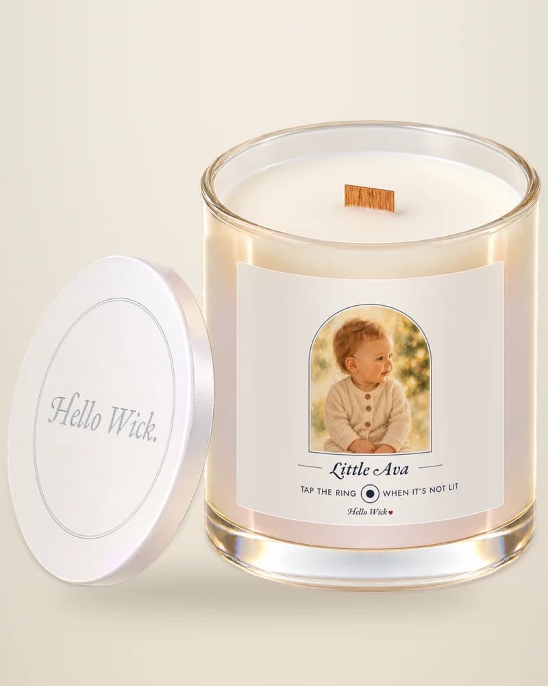 A Hello Wick candle labelled Little Ava, with a watercolour of the baby, its lid beside it